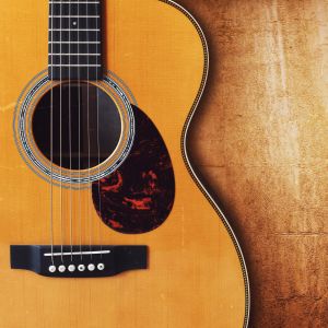 Image of a classical guitar against a wood background