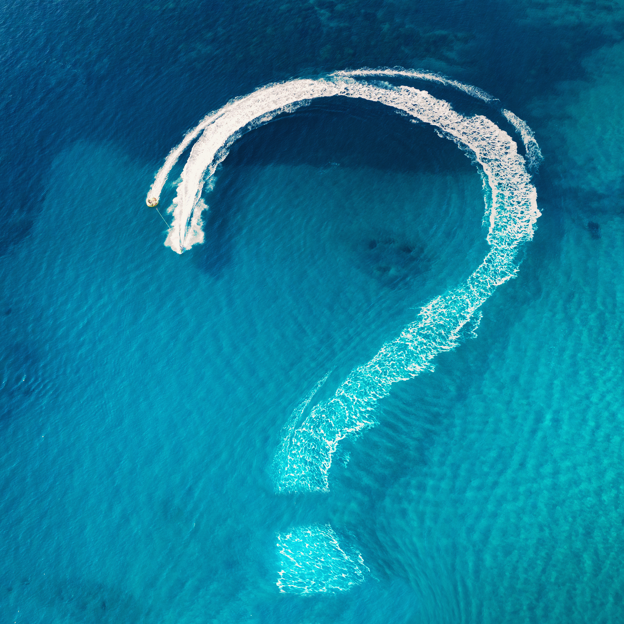 A white question mark on a background of turquoise water