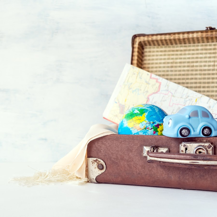 a brown suitcase holding a map, a small globe, a scarf, and a blue toy car